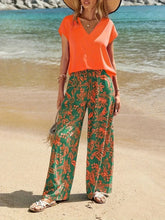 Front view of orange V-neck top with green floral pants set – Voguelle