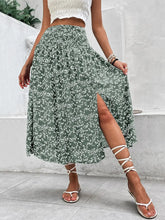 Front view of high waist smocked printed green skirt with slit on model – Voguelle