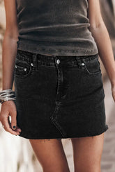 Front view of black denim mini skirt with frayed hem on model – Voguelle