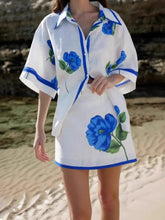 Close-up of blue floral print detail on button-up shirt and mini skirt – Voguelle