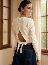 Back view of Cutout Bow Back Texture Knit Sweater in white with tie detail on model – Voguelle