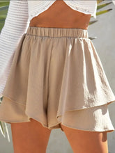 Front view of high-waisted ruffle layered shorts in beige on model – Voguelle