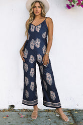 Front view of printed navy sleeveless V-neck jumpsuit on model – Voguelle