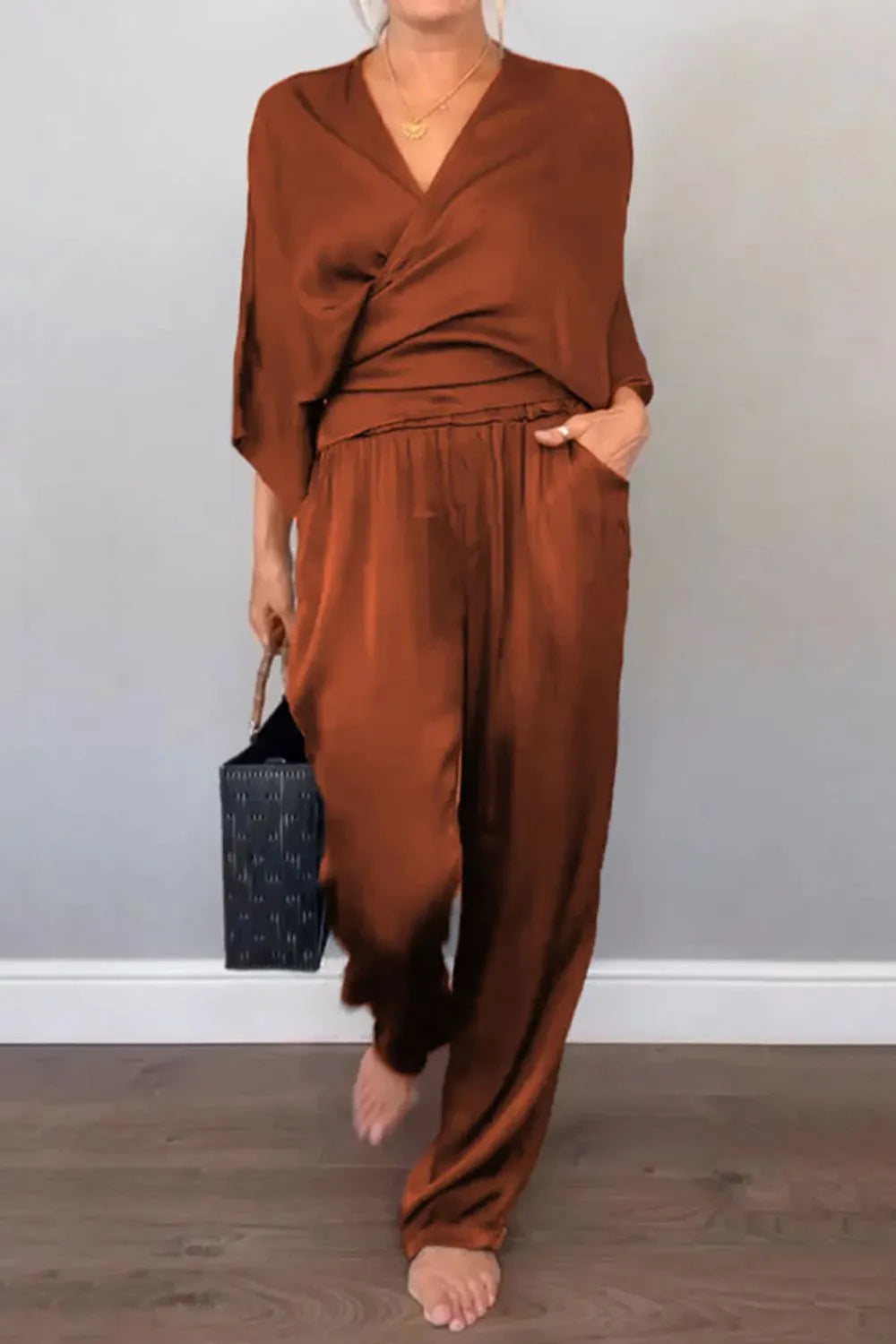 Front view of black wrap surplice jumpsuit with wide-leg pants – Voguelle