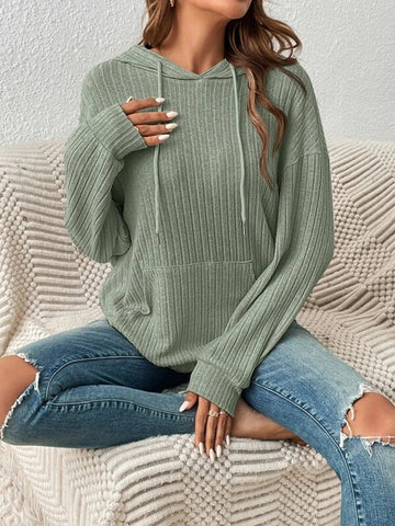 Model seated wearing sage green ribbed hoodie with drawstring detail – Voguelle