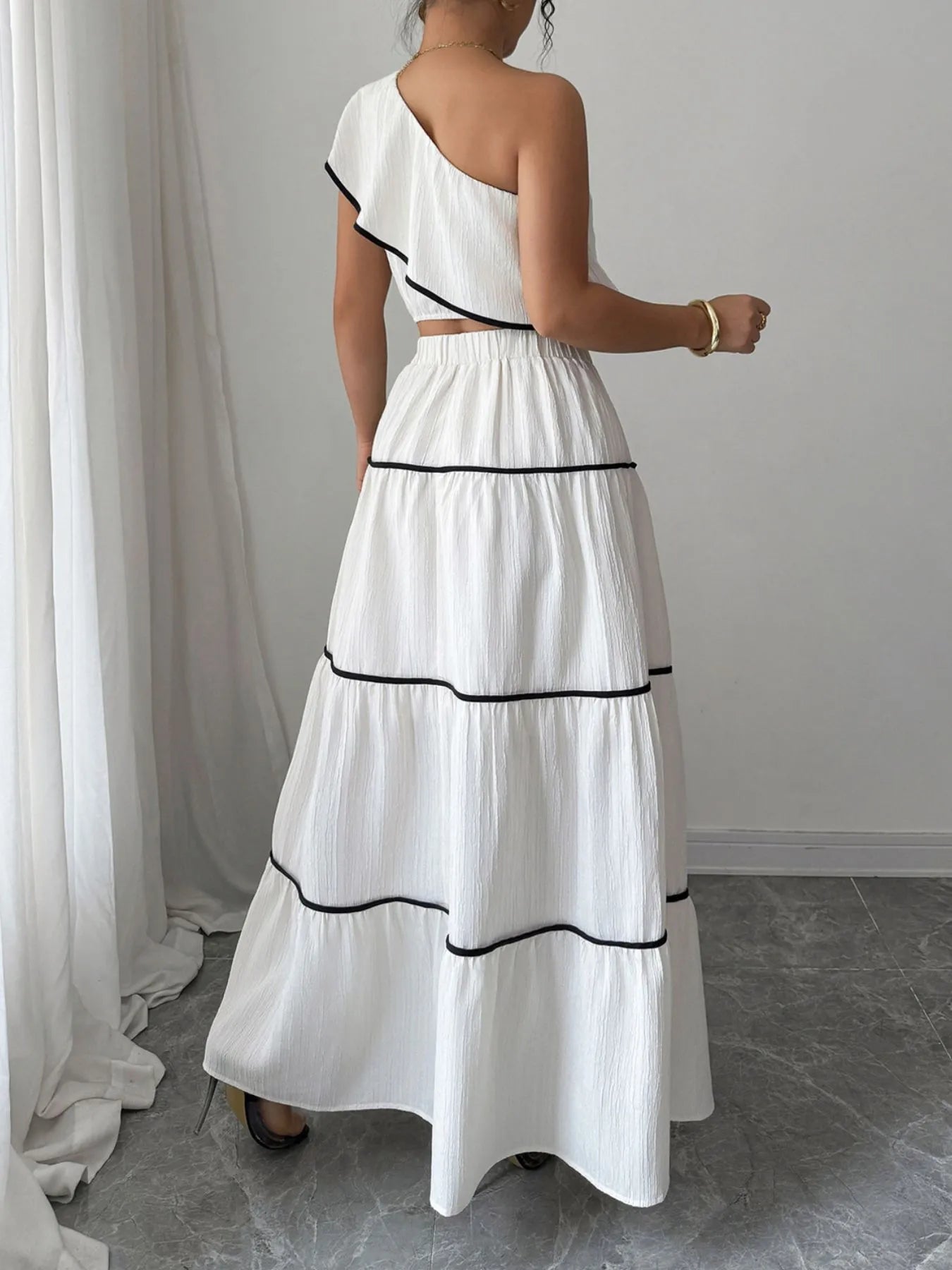 Back view of white one-shoulder ruffle top and maxi skirt set on model – Voguelle