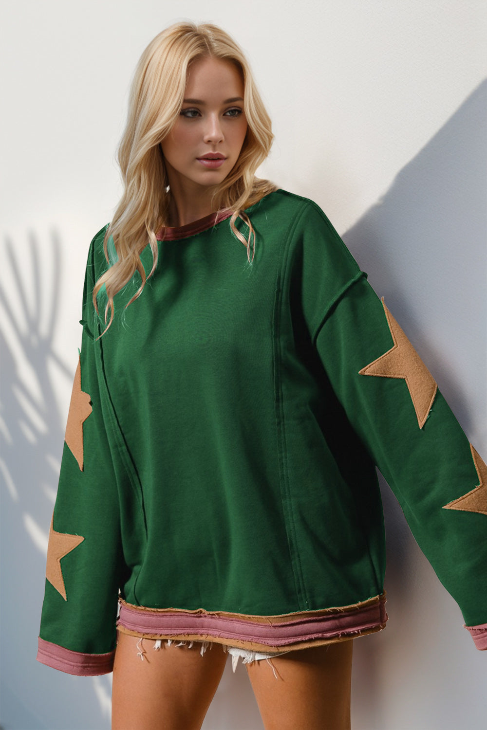 Model wearing green sweatshirt with star sleeve patches – Voguelle