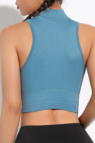 Back view of a blue mock neck ribbed sports tank, showcasing its stretchy fabric and fitted design.