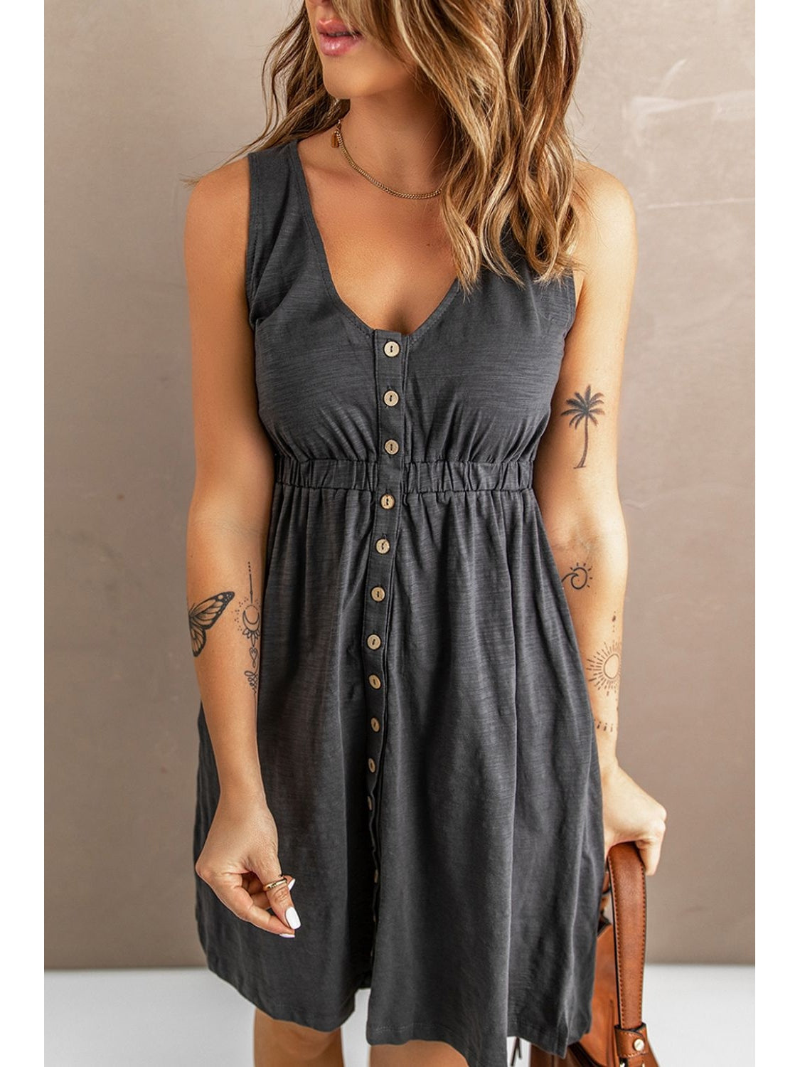 Hemline close-up of black sleeveless button down dress – Voguelle