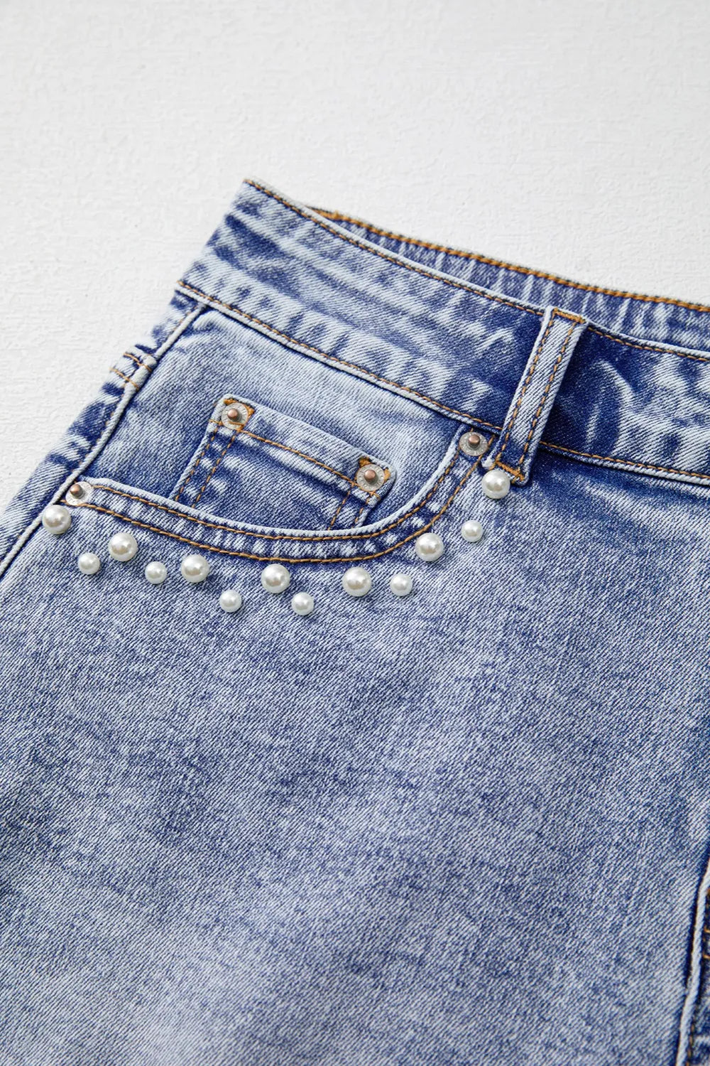 Fabric detail of light blue denim with pearl studs – Voguelle