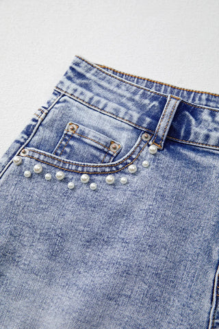 Fabric detail of light blue denim with pearl studs – Voguelle