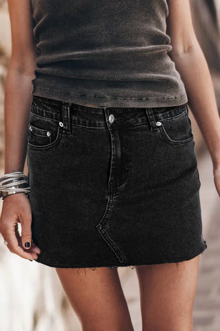 Front view of black frayed hem denim mini skirt on model with grey tank top – Voguelle
