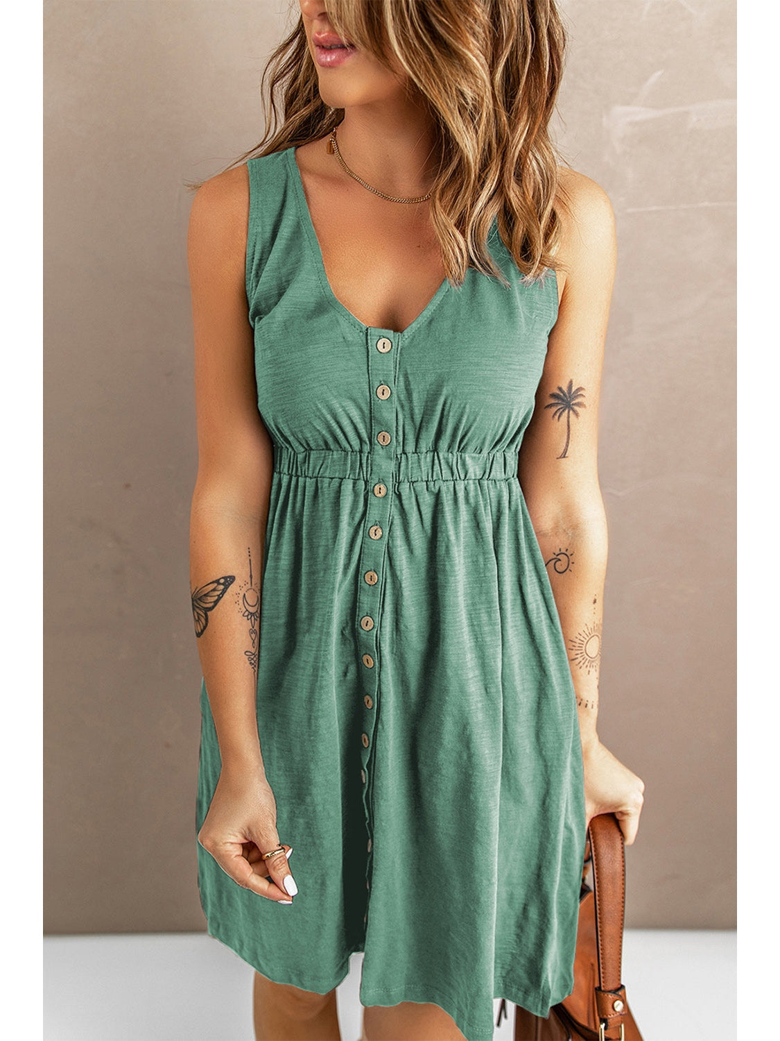 Model styling bag with sleeveless black button down dress – Voguelle