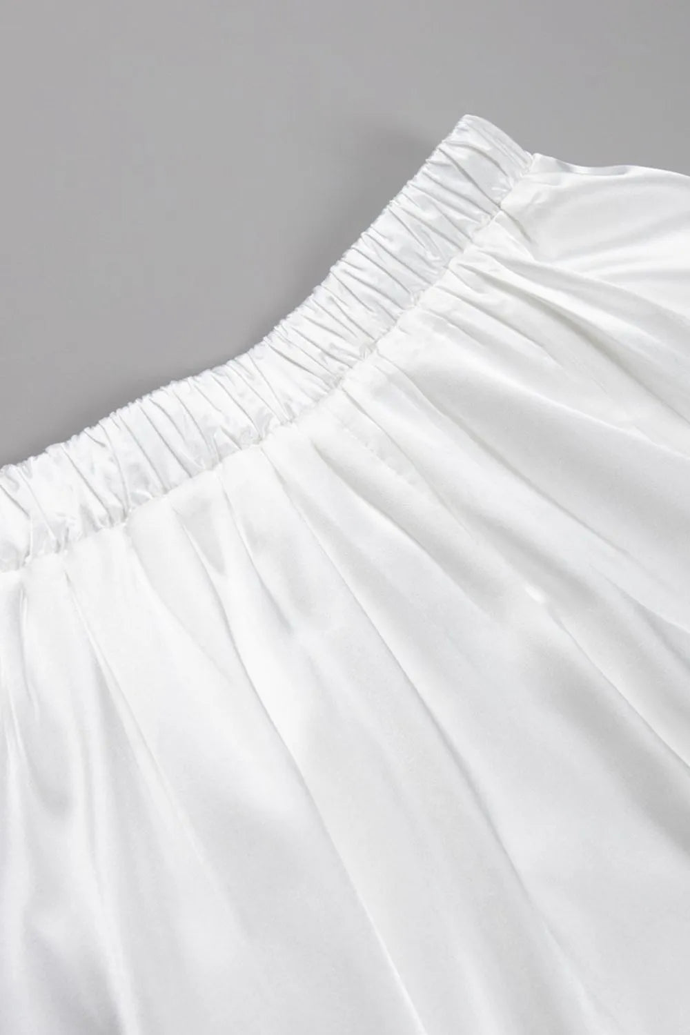 Close-up of back elastic waistband on white satin midi skirt – Voguelle