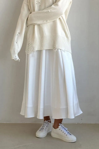 Front view of white satin midi skirt on model, paired with black top – Voguelle
