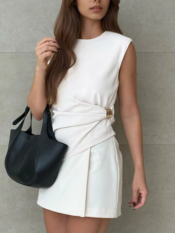 Close-up of round neck sleeveless white dress styled with black handbag – Voguelle