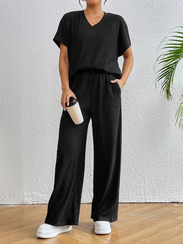 Close-up of ribbed black V-neck short sleeve blouse on model – Voguelle