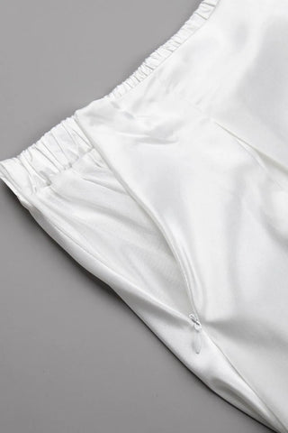 Detail shot of smooth satin fabric and hem of white midi skirt – Voguelle