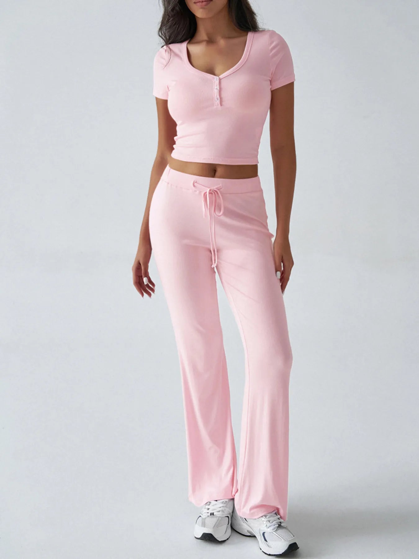 Close-up of pink ribbed crop top with button detail on model – Voguelle