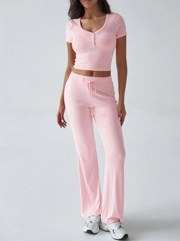 Close-up of pink ribbed crop top with button detail on model – Voguelle