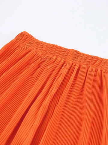 Close-up of pleated orange fabric texture – Voguelle