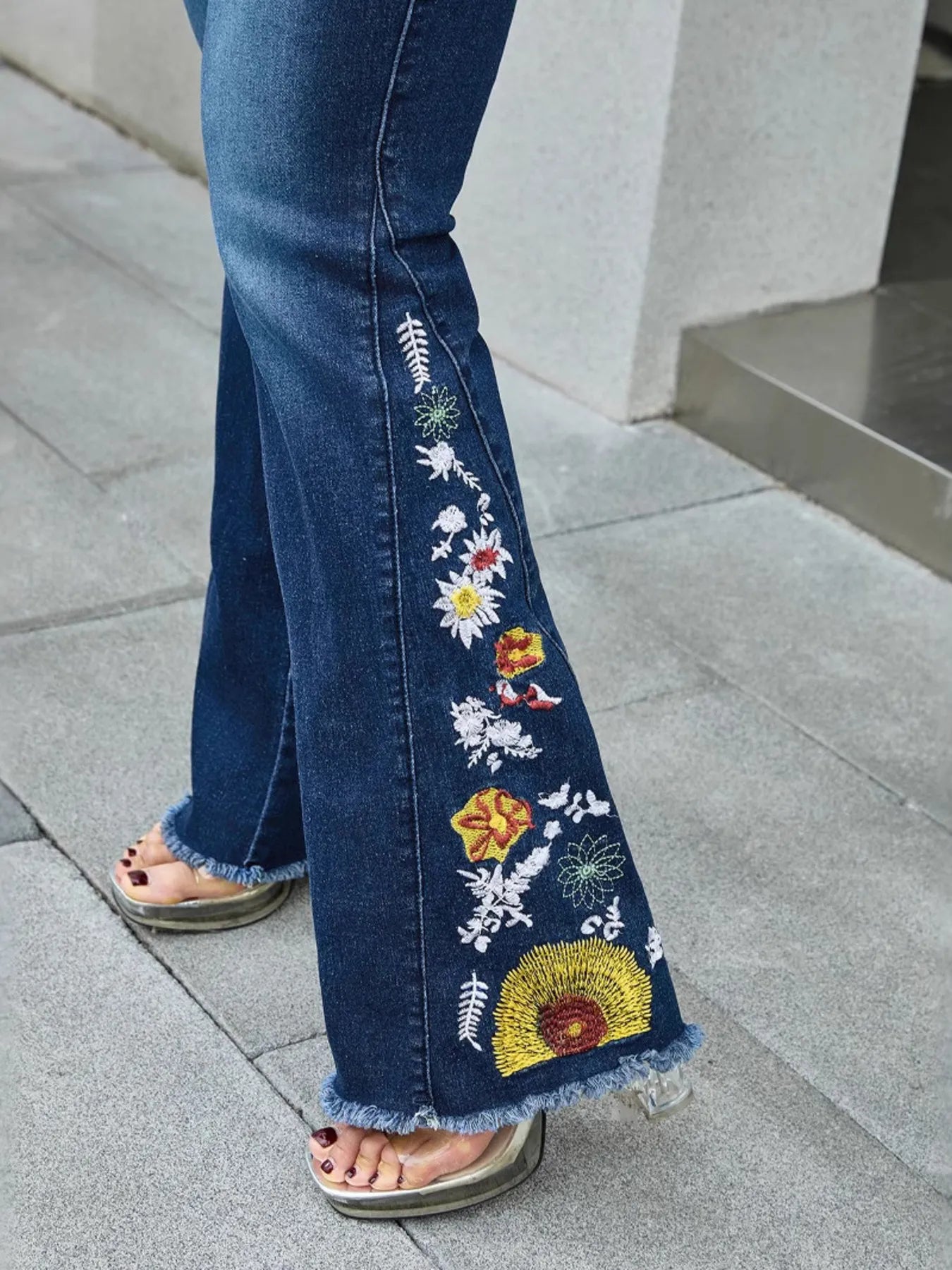 Close-up of floral embroidery on blue raw hem jeans – Voguelle