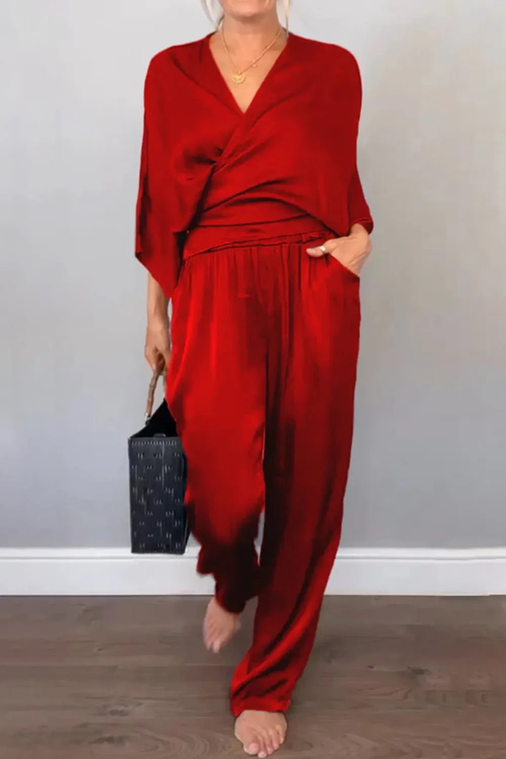 Black jumpsuit with draped neckline and wide-leg silhouette – Voguelle