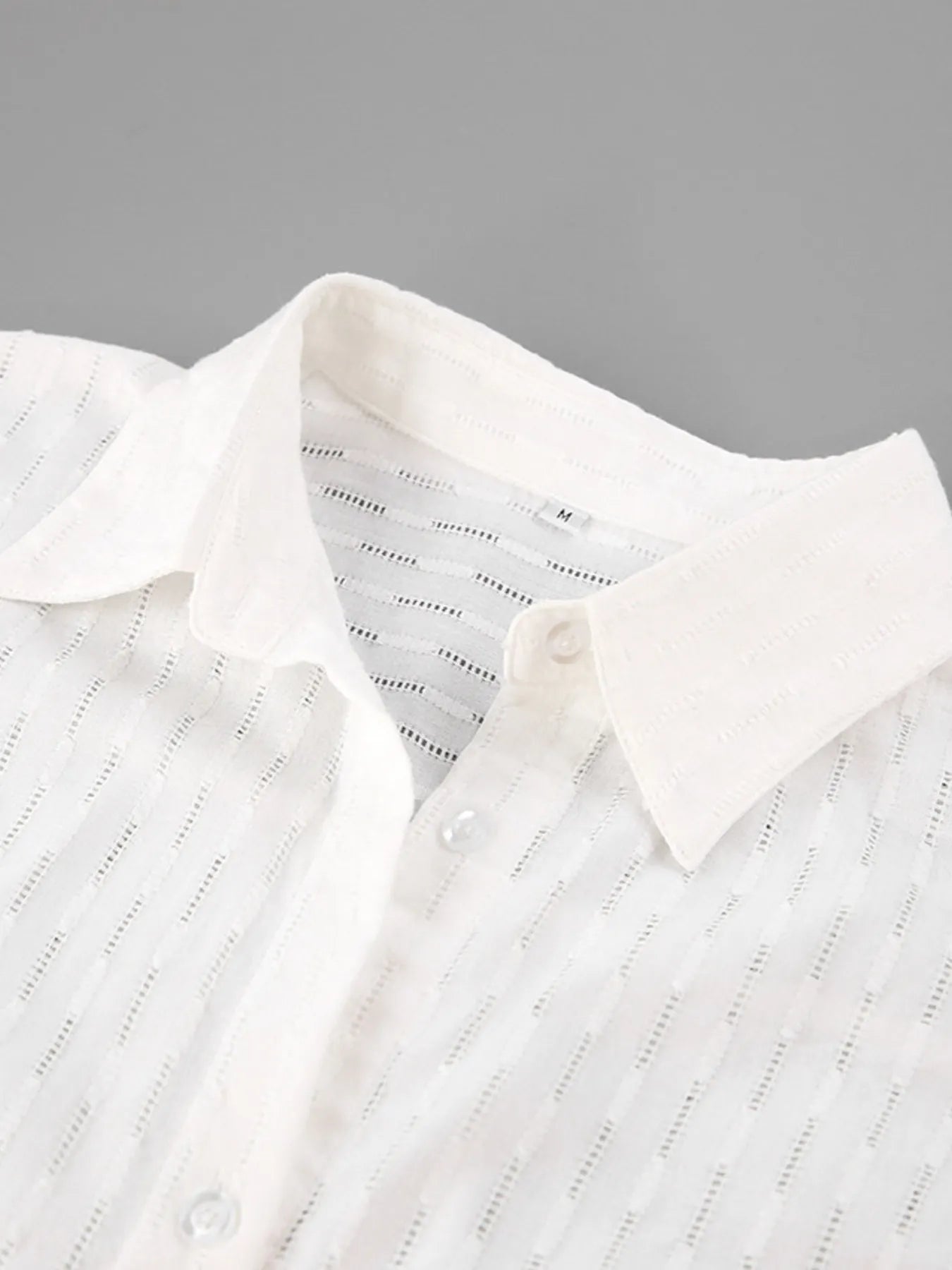 Detail of button front and cuff on textured marigold shirt – Voguelle