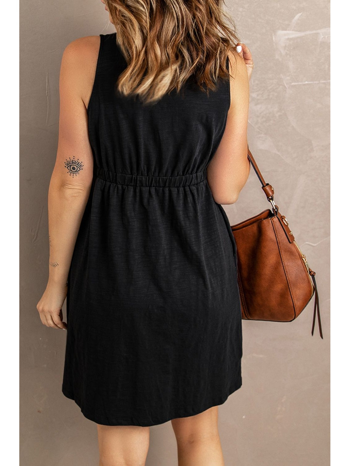 Back view of black sleeveless mini dress with button detail – Voguelle
