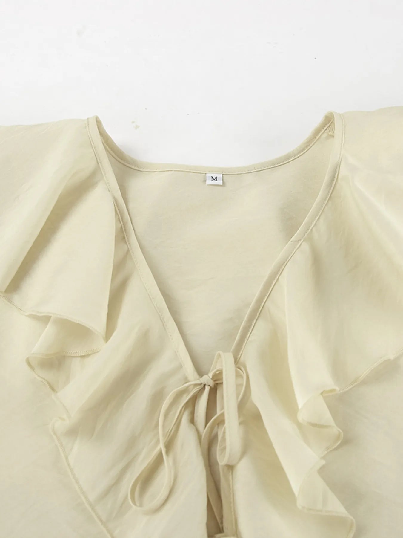 Model wearing Ruffled V-Neck Top with feminine ruffle accents – Voguelle