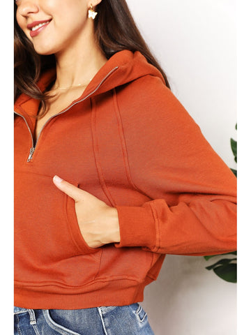 Front view of half-zip cropped hoodie in rust orange on model – Voguelle