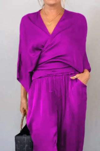 Front pose of model in black surplice jumpsuit with relaxed fit – Voguelle
