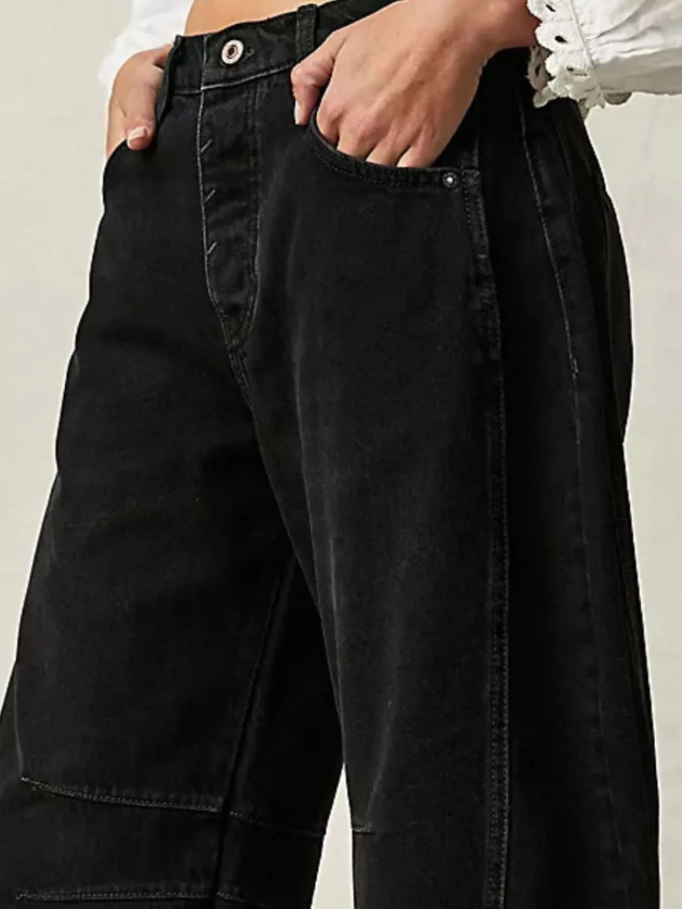Side view of black wide leg jeans styled on model – Voguelle
