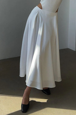 Front view of white satin midi skirt on model with black top and heels – Voguelle