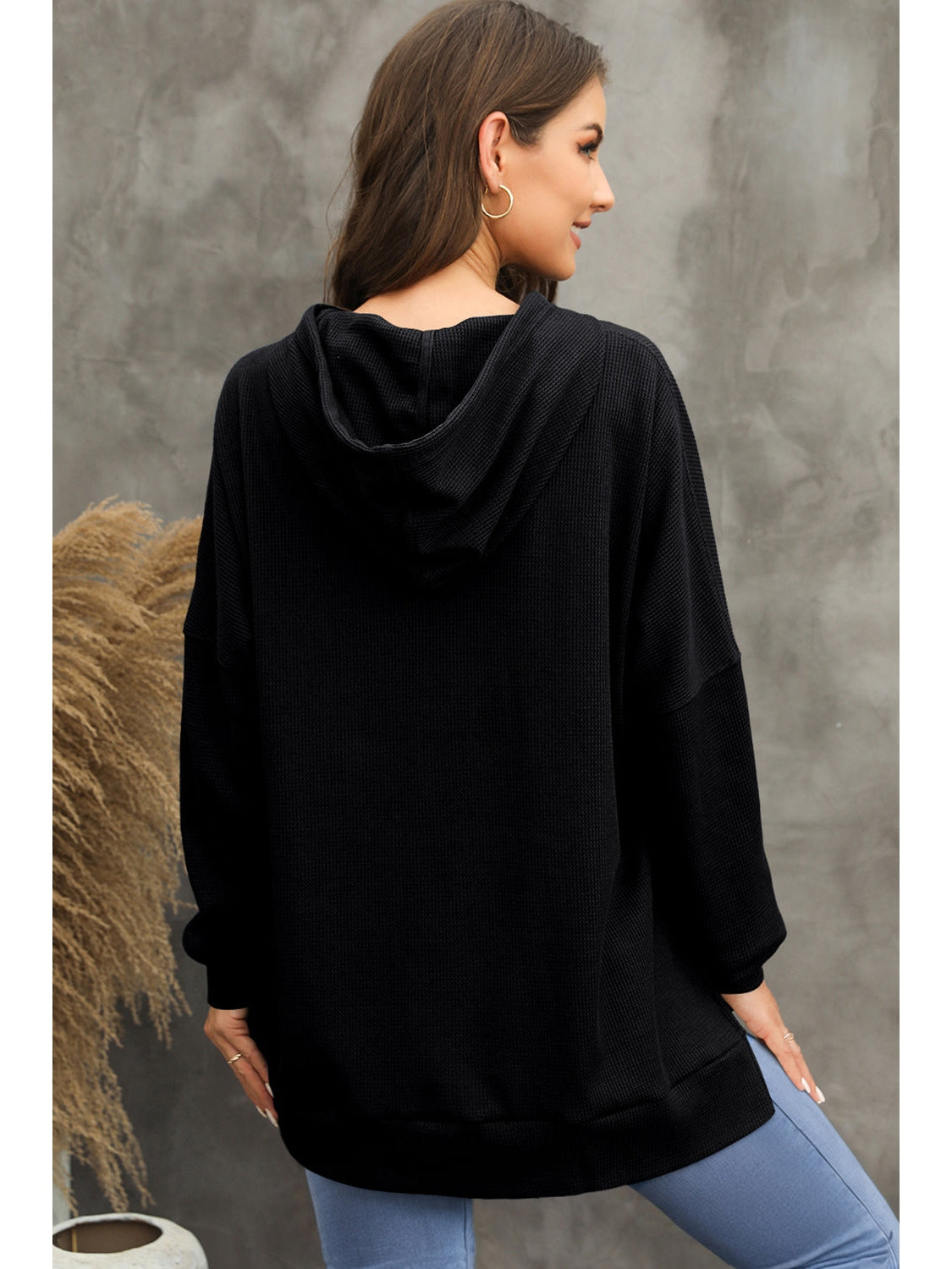 Model’s hand in pocket of gray waffle-knit hoodie – Voguelle