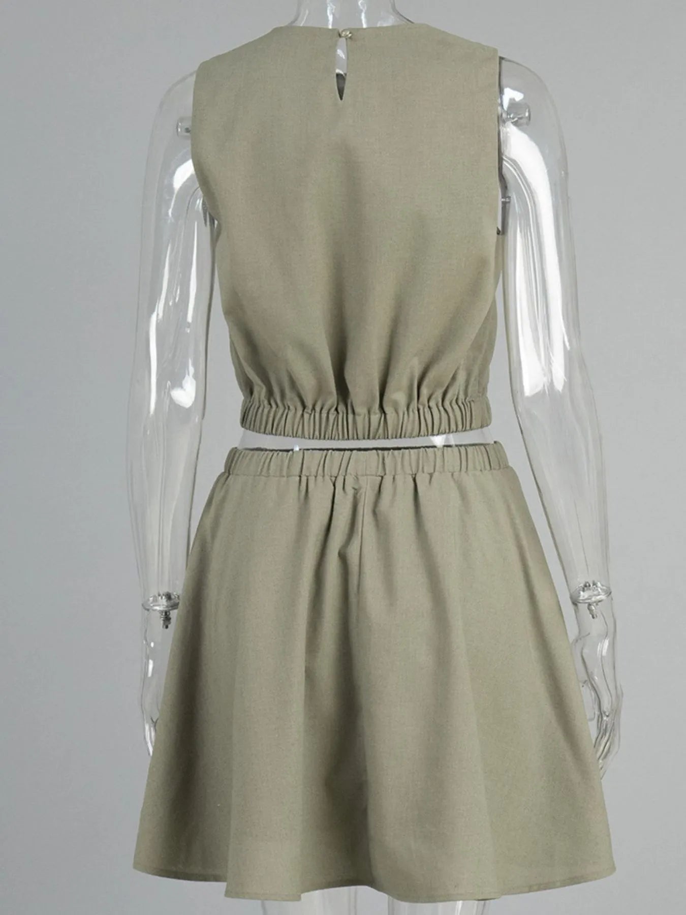 Model styling beige sleeveless skirt set with woven bag – Voguelle