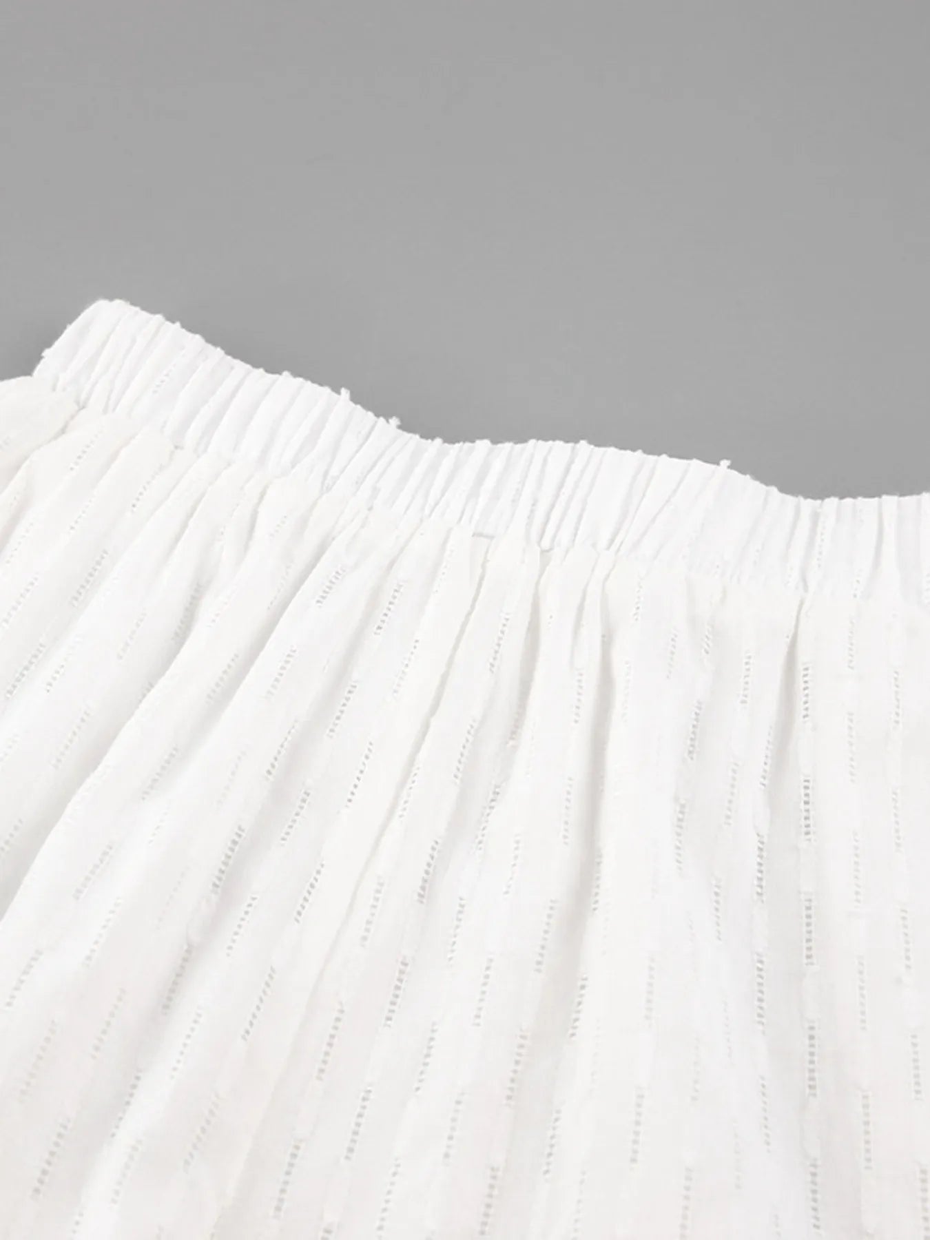 Model styling white textured button-up shirt casually – Voguelle