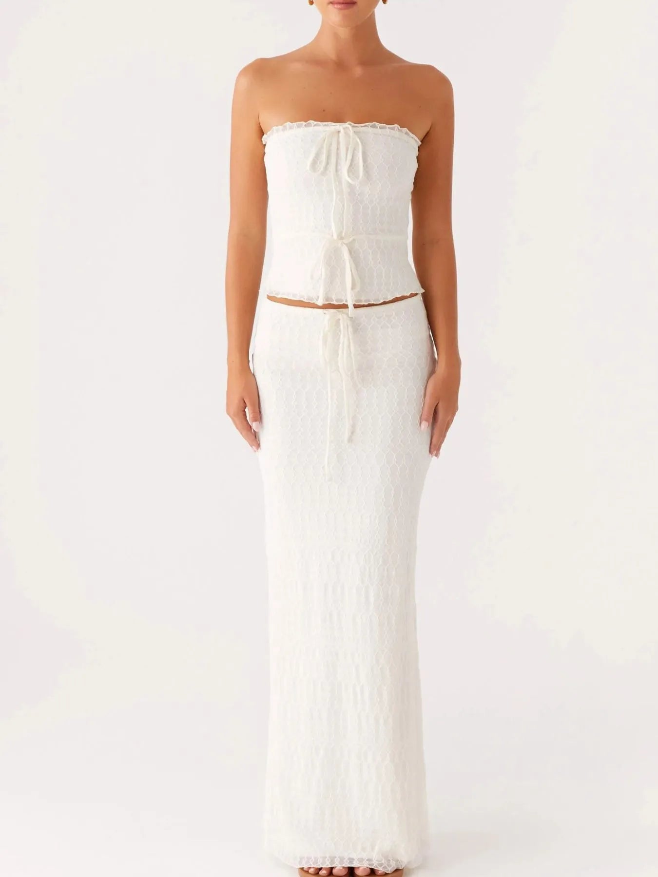 Model posing in strapless lace two-piece set with maxi skirt – Voguelle