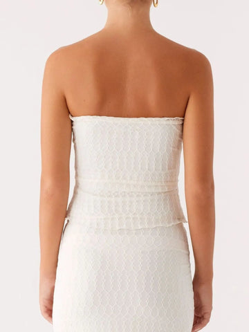 Side pose of model wearing lace tube top and flowy maxi skirt – Voguelle