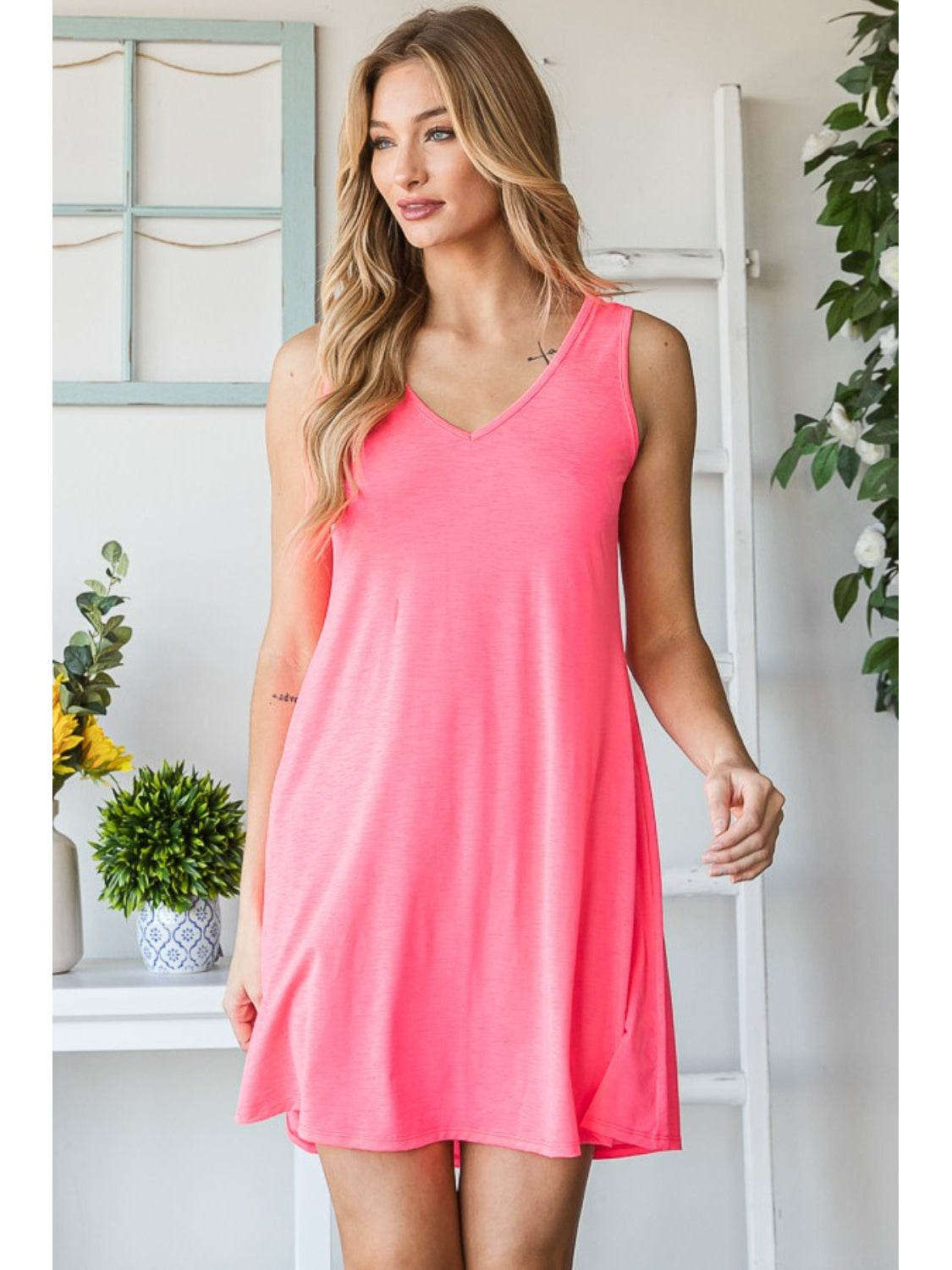 Lifestyle image of model wearing pink V-neck mini tank dress – Voguelle