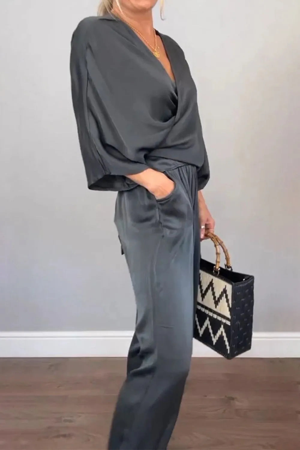 Model wearing black surplice V-neck jumpsuit with short wide sleeves – Voguelle