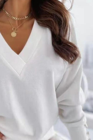 Model wearing blue V-neck sweatshirt with gold button detail – Voguelle