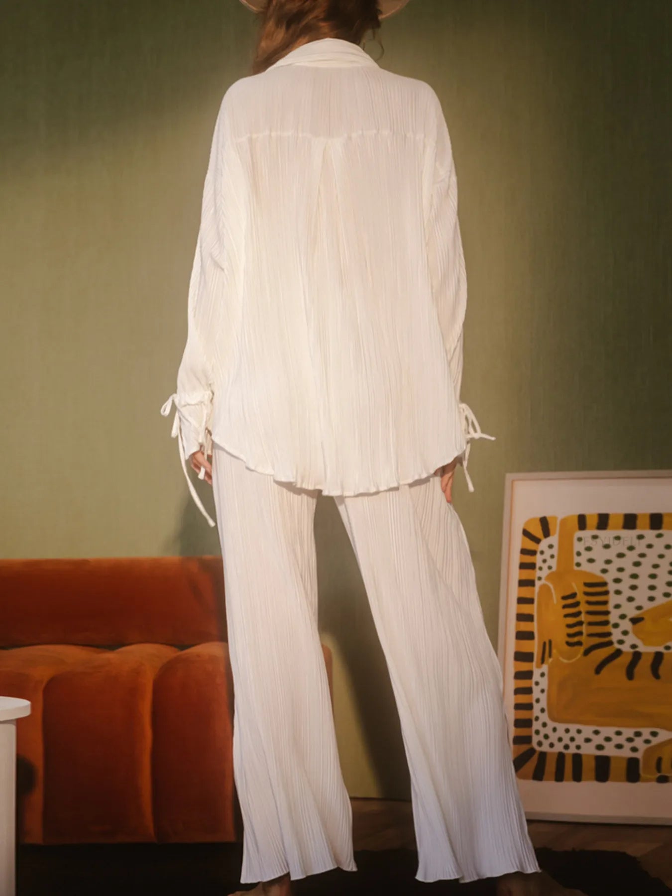 Model wearing black pleated button-up top and trousers – Voguelle