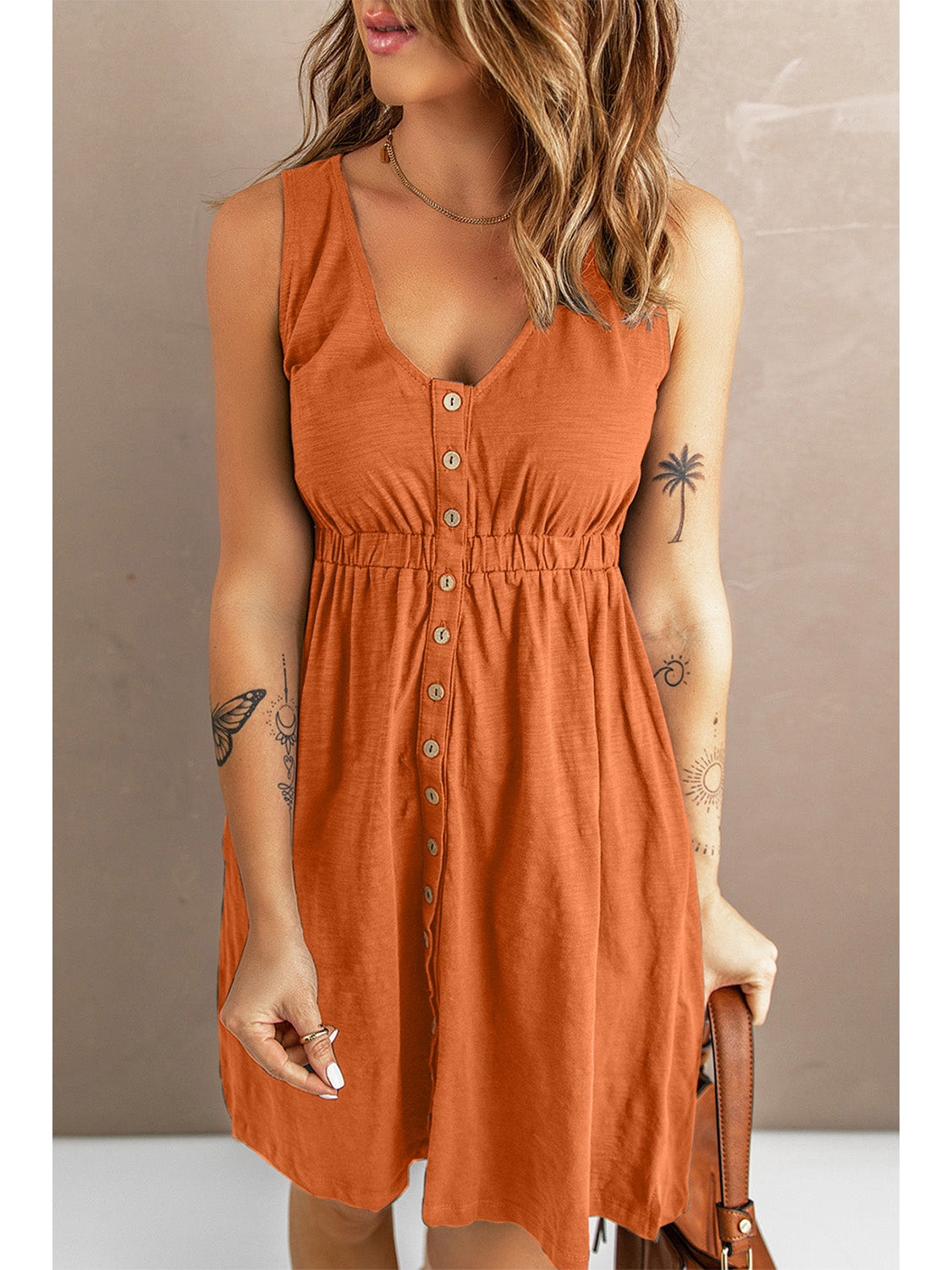 Model with hand on hip in sleeveless black button down dress – Voguelle