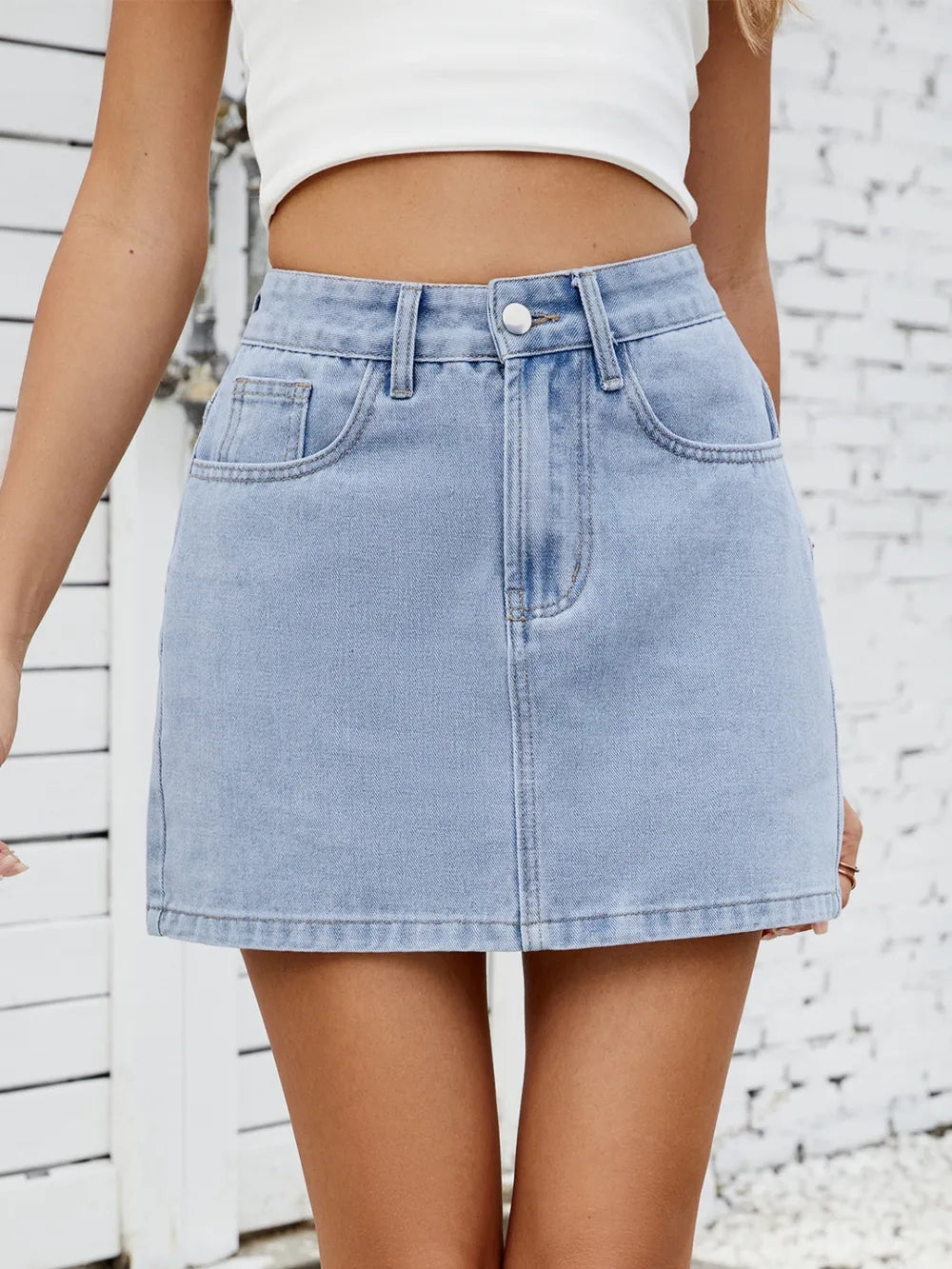 Model wearing light blue solid mini denim skirt with white top, full outfit – Voguelle