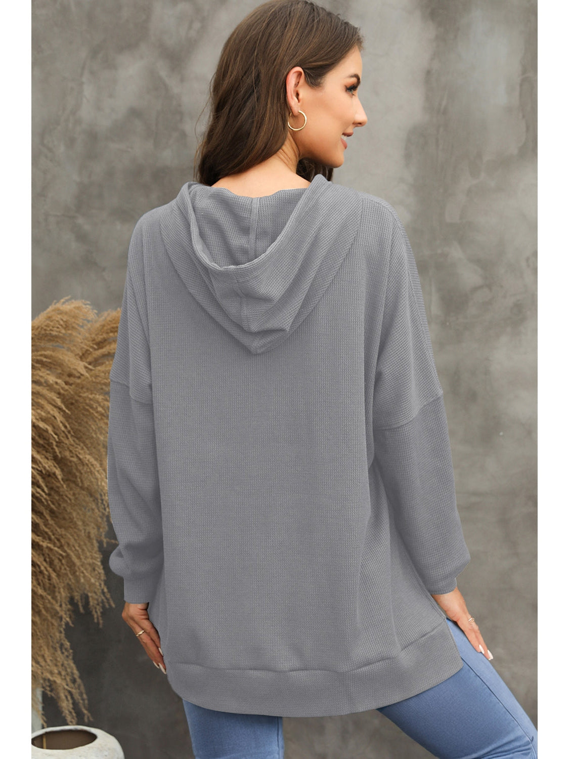 Side profile of model wearing gray waffle-knit hoodie – Voguelle