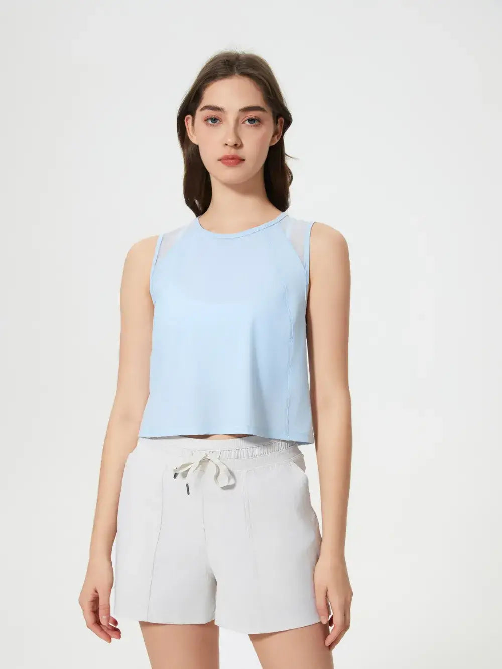 Front view of Millennia Cropped Active Tank in beige on model – Voguelle